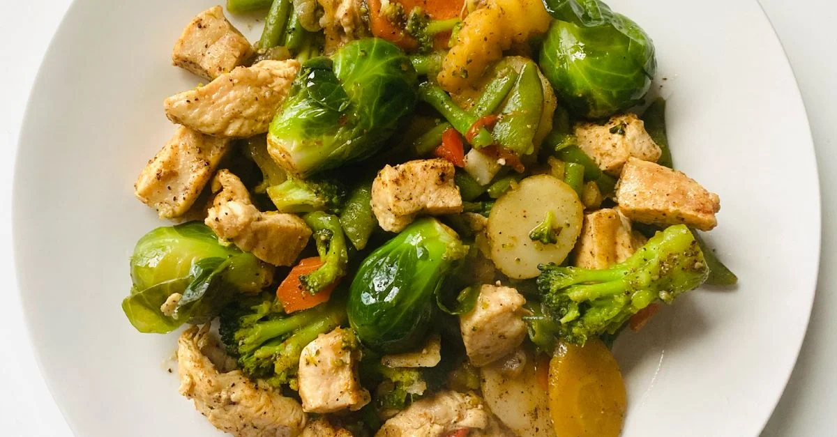 Délicieux sauté de poulet et de légumes dans une assiette blanche pour un repas sain.