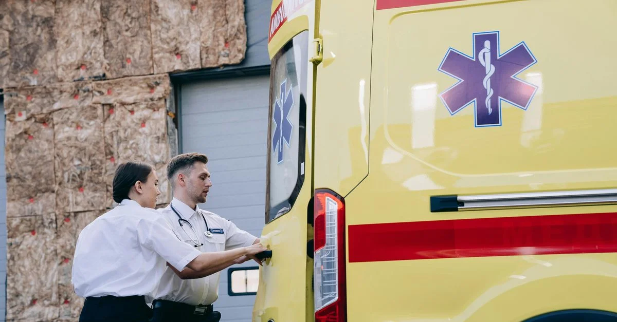 Deux paramédics ferment les portes arrière d'une ambulance, se préparant à une intervention d'urgence.