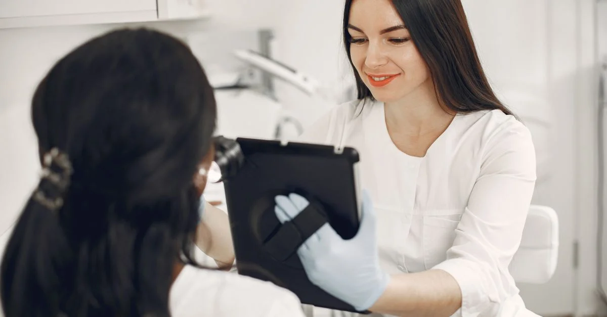 Une esthéticienne consulte un client à l'aide d'une tablette dans un cadre moderne de spa de beauté.