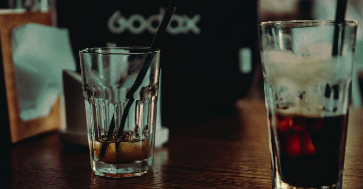 Deux verres avec des pailles sur une table en bois, évoquant une atmosphère chaleureuse.