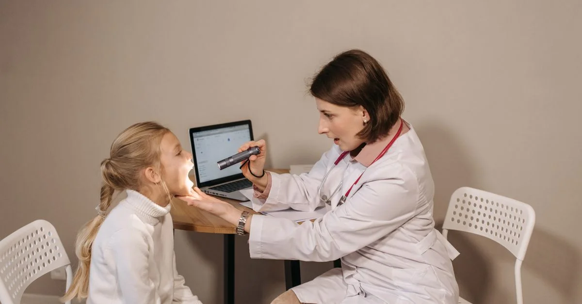 Une médecin examine un enfant dans un cadre clinique, assurant des soins médicaux appropriés et une attention.