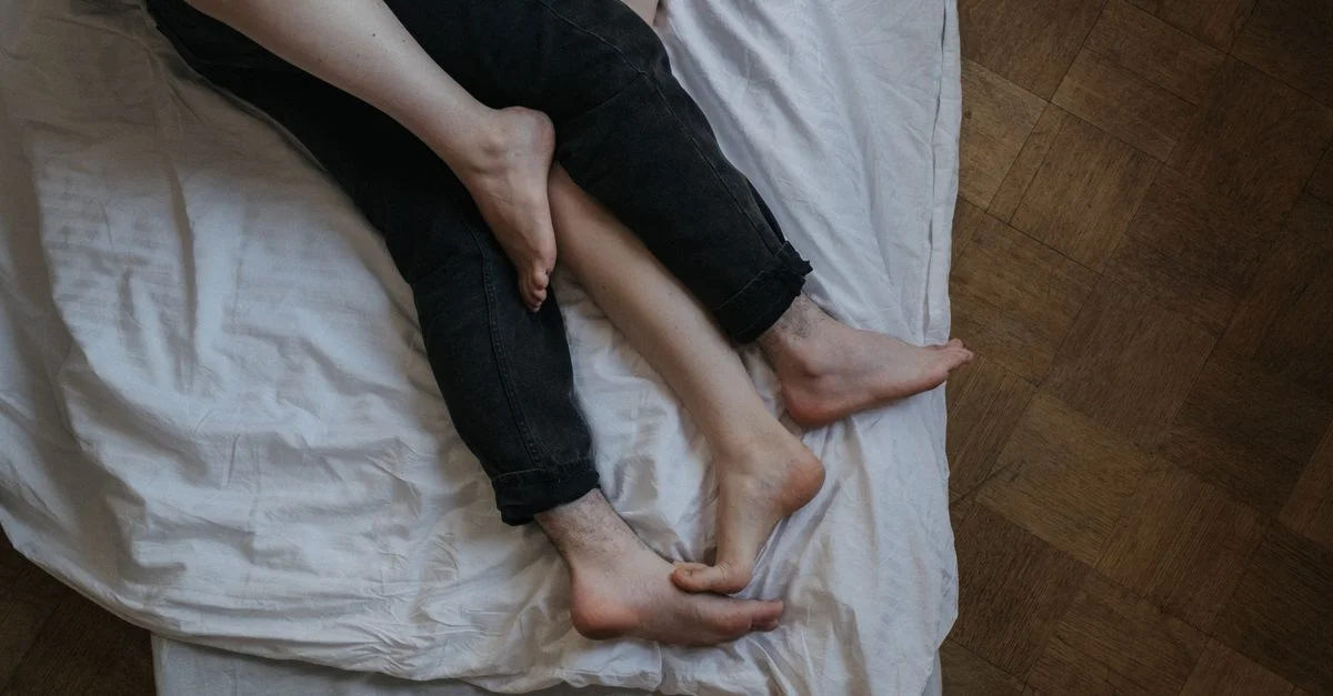 Une scène intime d'un couple se détendant pieds nus dans une chambre confortable, mettant en avant l'amour et la complicité.