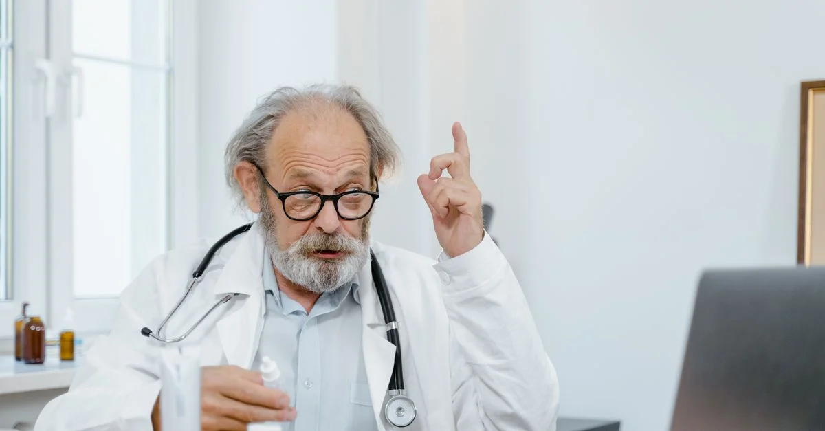 Médecin senior en blouse blanche ayant une consultation en ligne. Professionnel de la santé utilisant la technologie pour les soins.