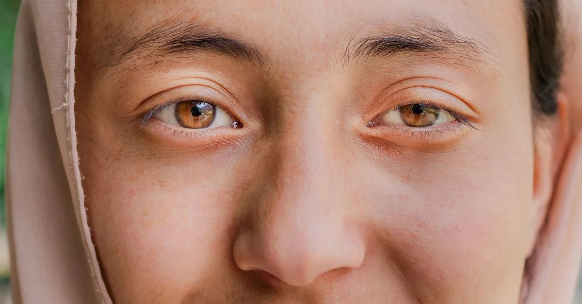 Gros plan détaillé des yeux et du visage d'une femme, capturant l'émotion.