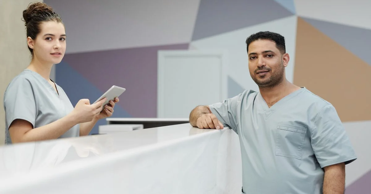 Membres du personnel médical en tenues de travail dans la zone de réception d'une clinique moderne.