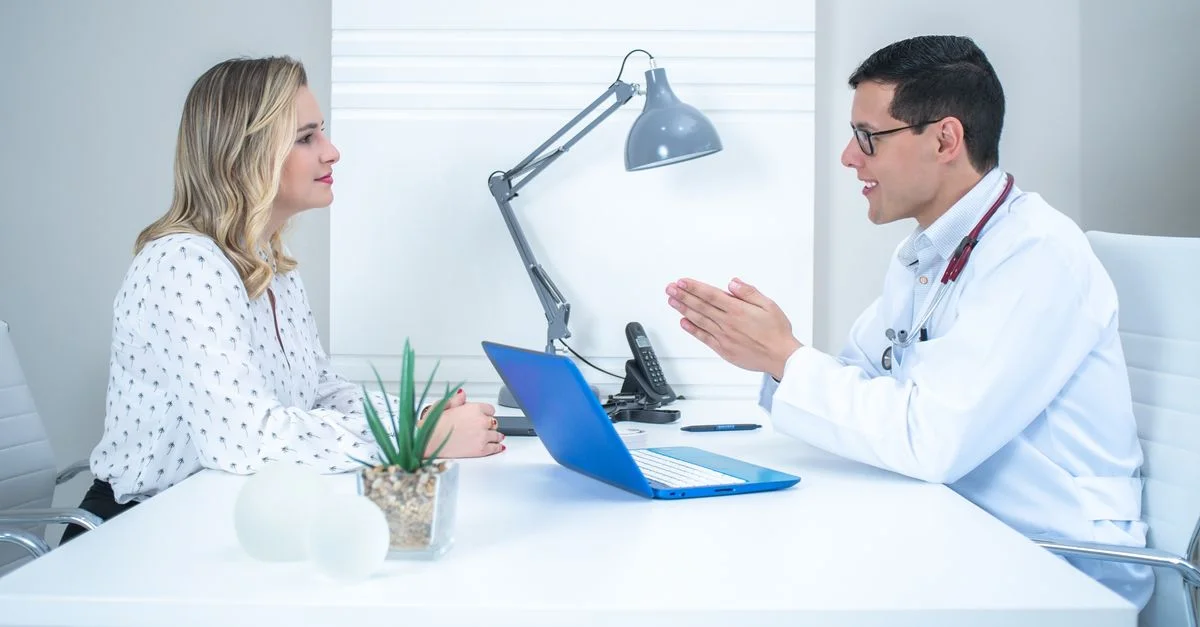 Un médecin effectue une consultation avec un patient dans un bureau médical moderne et lumineux.