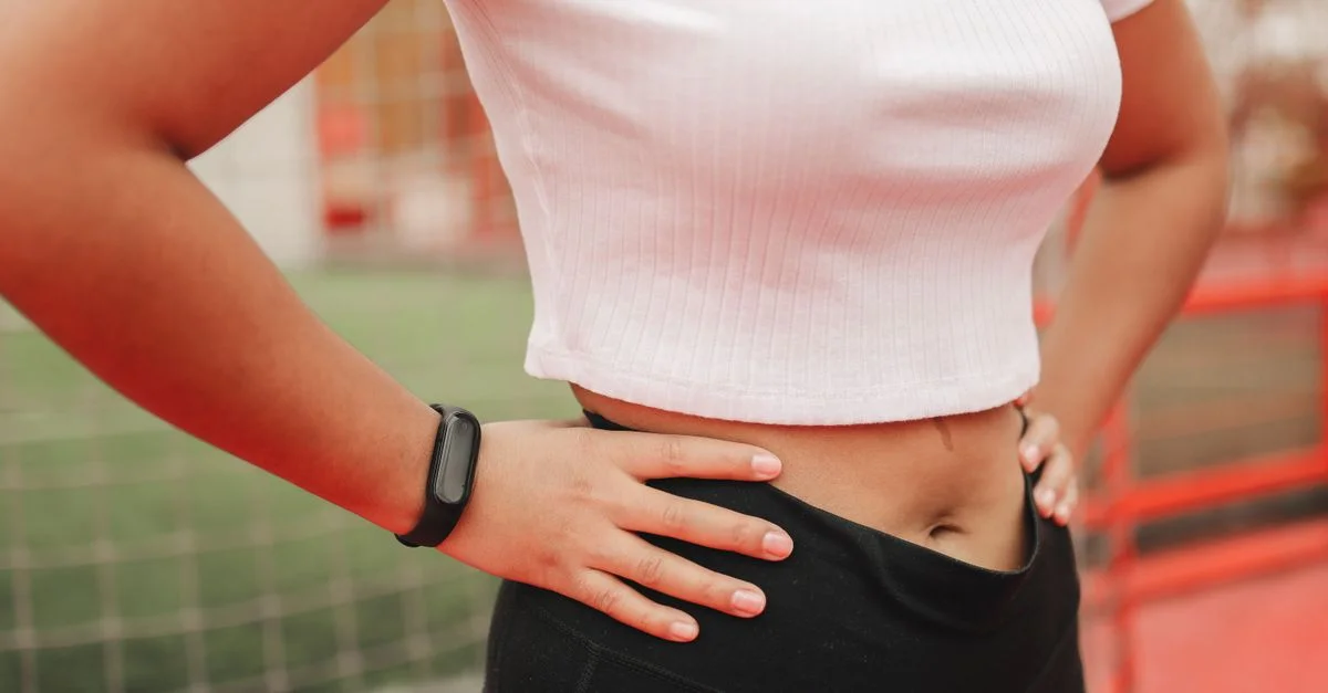 Gros plan sur une femme portant un suivi sportif dans un cadre sportif, soulignant un style de vie actif.