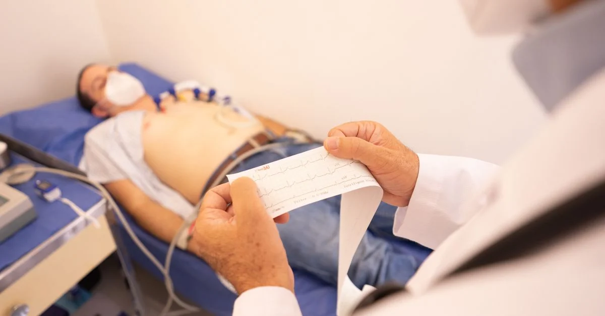 Un médecin analyse un impré de ECG pendant qu'un patient est surveillé dans une clinique médicale.