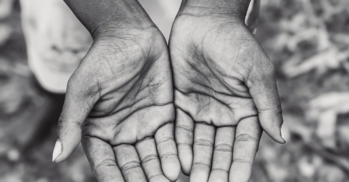 Une photo en noir et blanc capturant des mains ouvertes, symbolisant le don ou la réception.