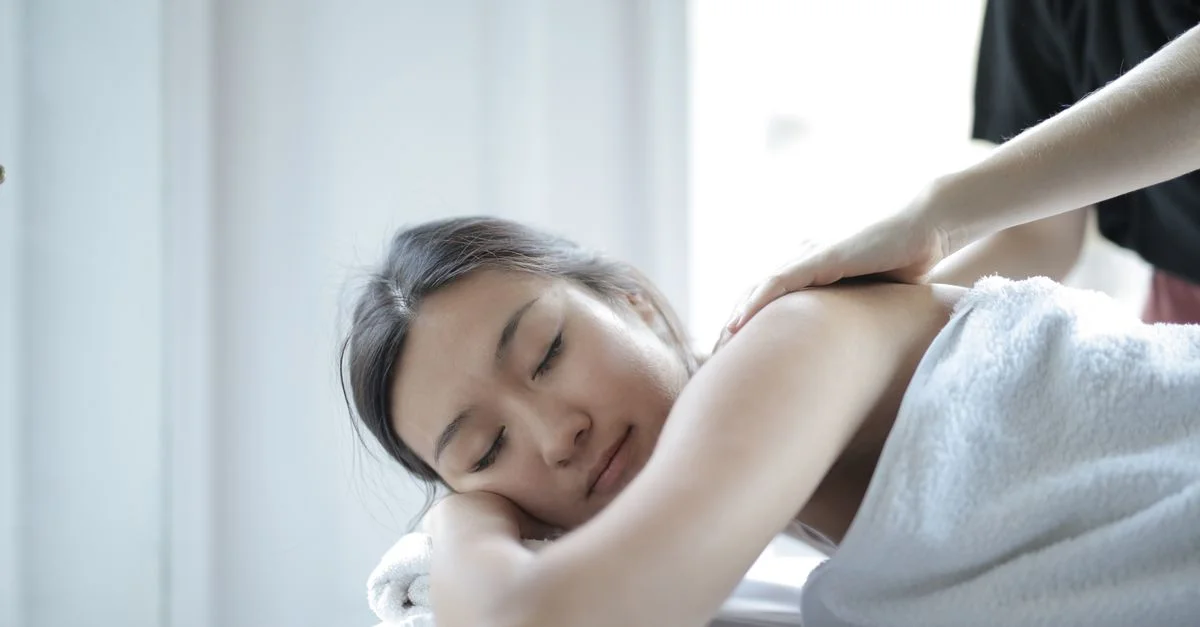 Femme asiatique profitant d'un massage corporel relaxant dans un spa pour se détendre et se ressourcer.
