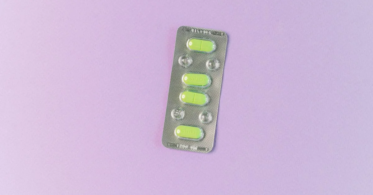 Vue du dessus de comprimés verts dans un blister sur un fond violet pastel. Idéal pour des thèmes de santé et de médication.