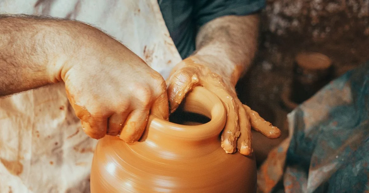 Artisan façonnant un pot en argile sur un tour de potier en rotation avec expertise.