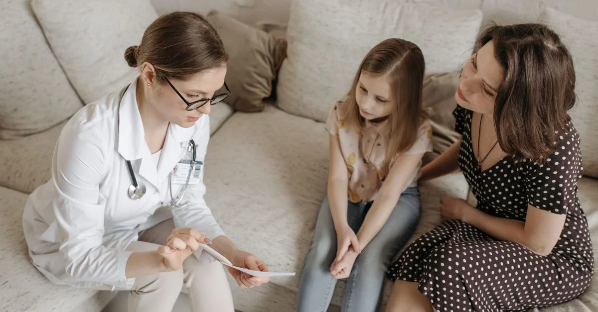Docteur expliquant le diagnostic à la mère et à la fille dans le cabinet.