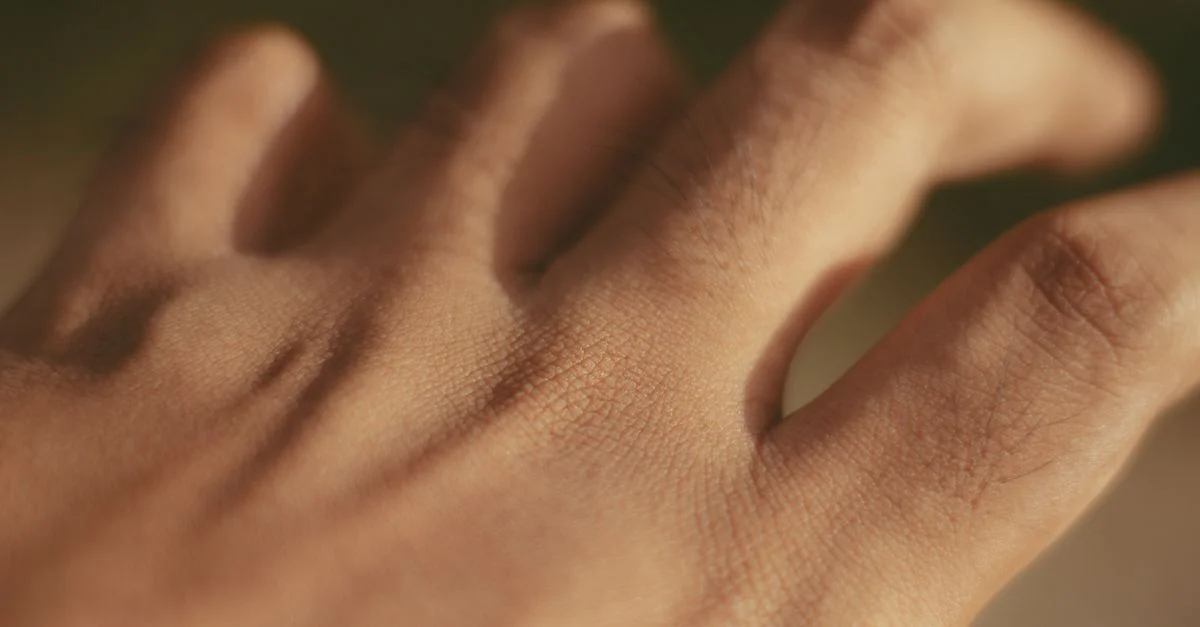 Prise de vue macro d'une main humaine mettant l'accent sur la texture de la peau et les pores à la lumière naturelle.