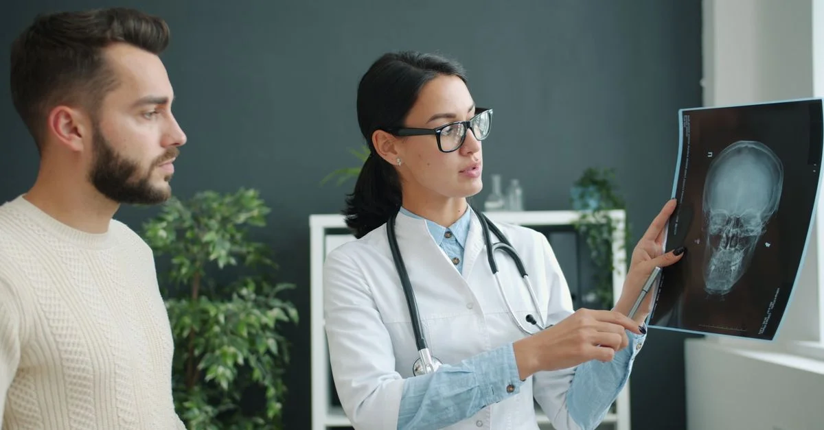 Un médecin explique les résultats d'une radiographie cérébrale à un patient dans un cabinet médical.