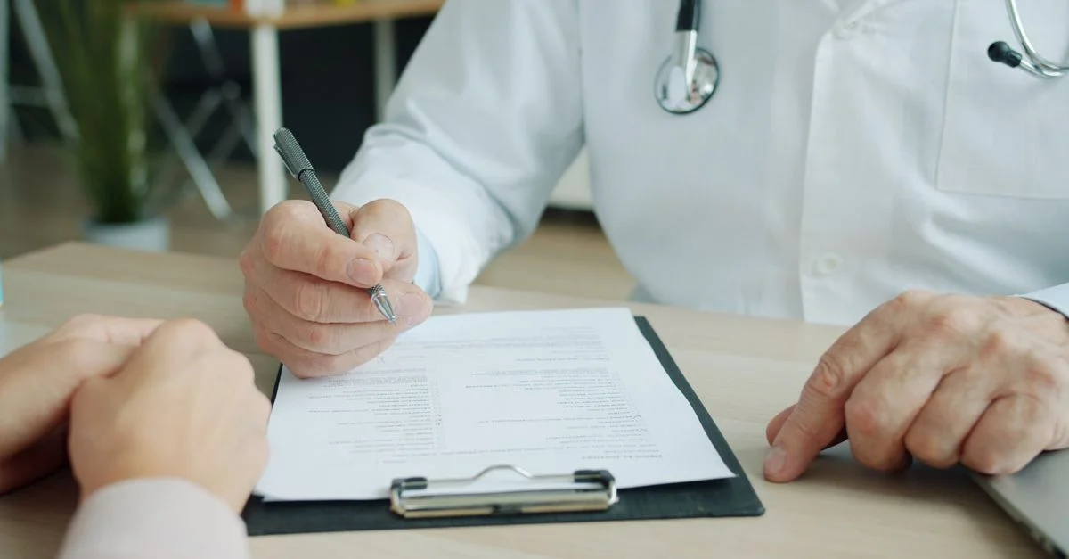 Gros plan sur un médecin et un patient examinant des documents médicaux lors d'une consultation.