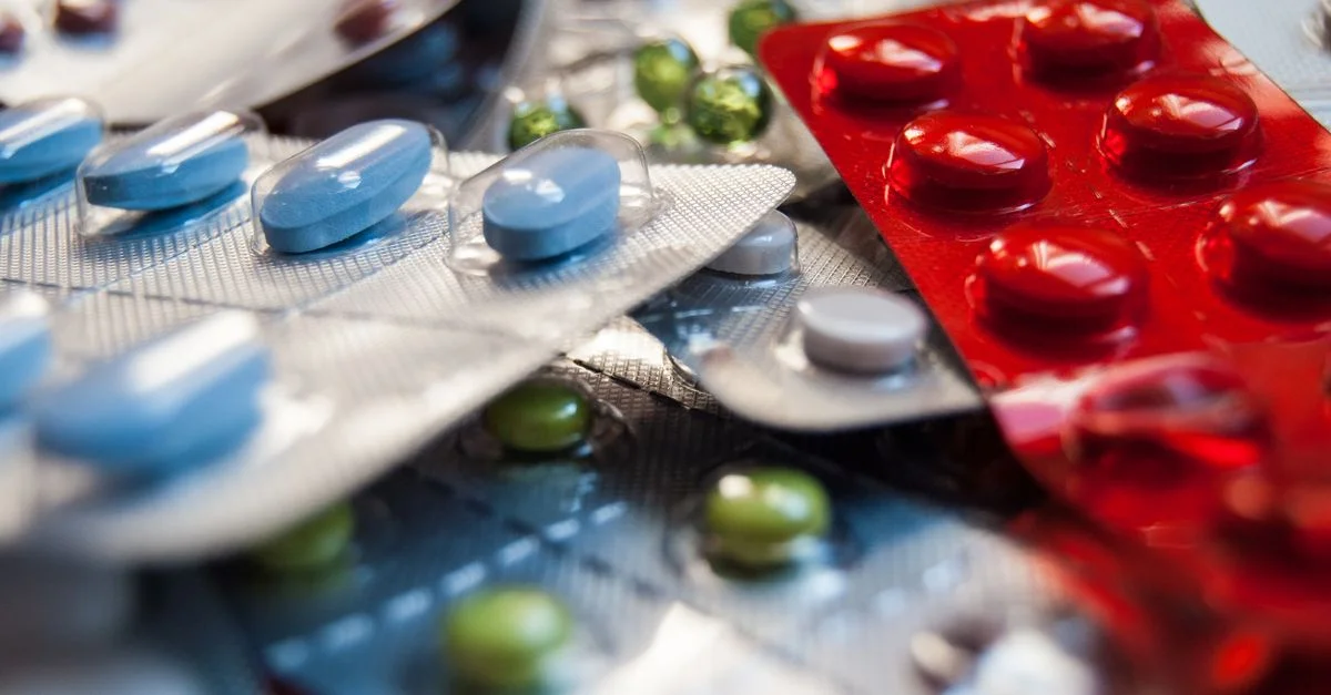 Gros plan de divers médicaments colorés dans des blisters.