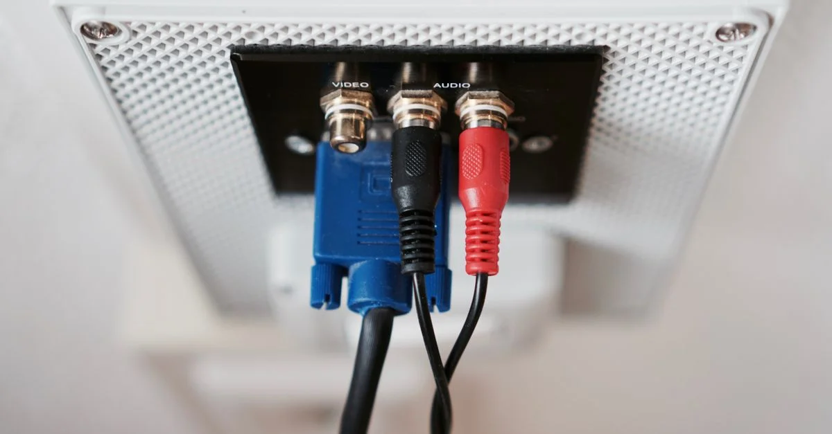 Vue détaillée des câbles d'entrée audio et vidéo connectés à une prise murale.