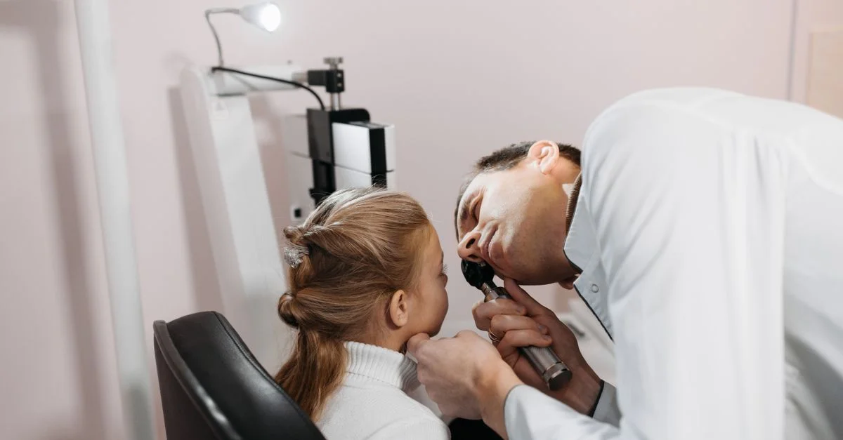 Un docteur examine l'oreille d'une jeune fille lors d'un rendez-vous médical dans une clinique.