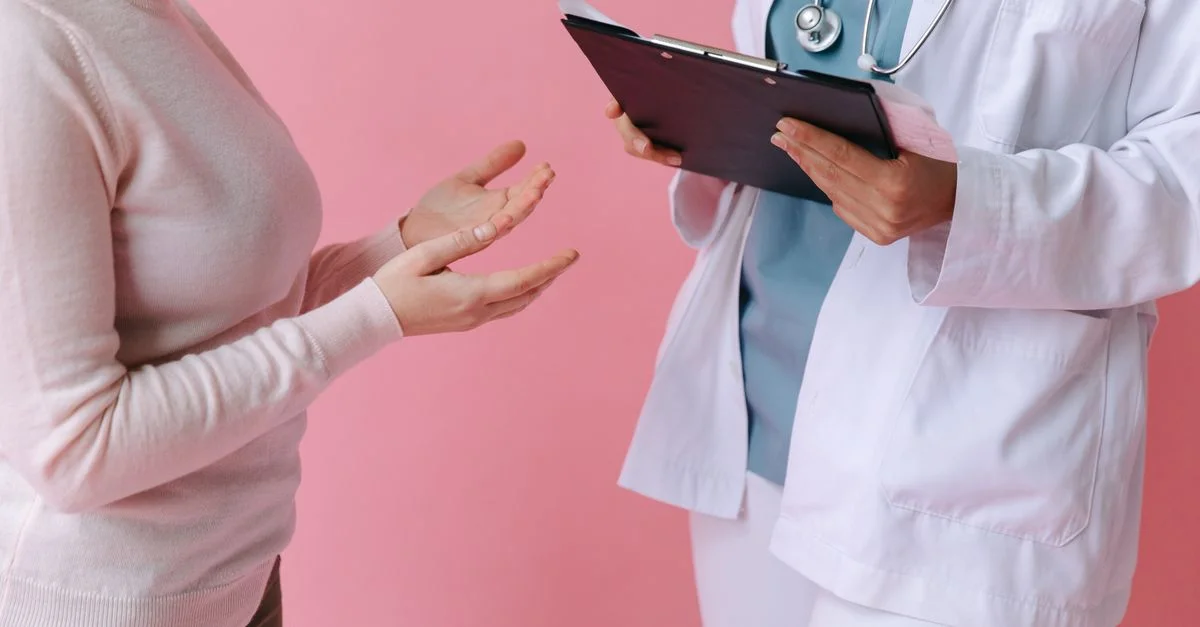 Gros plan sur un patient consultant un médecin avec un clipboard dans un cadre médical.