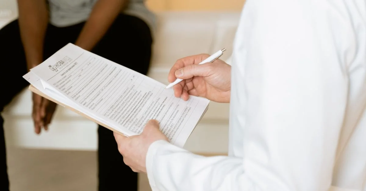Le professionnel de santé examine le formulaire médical lors de la consultation du patient dans un cadre clinique.