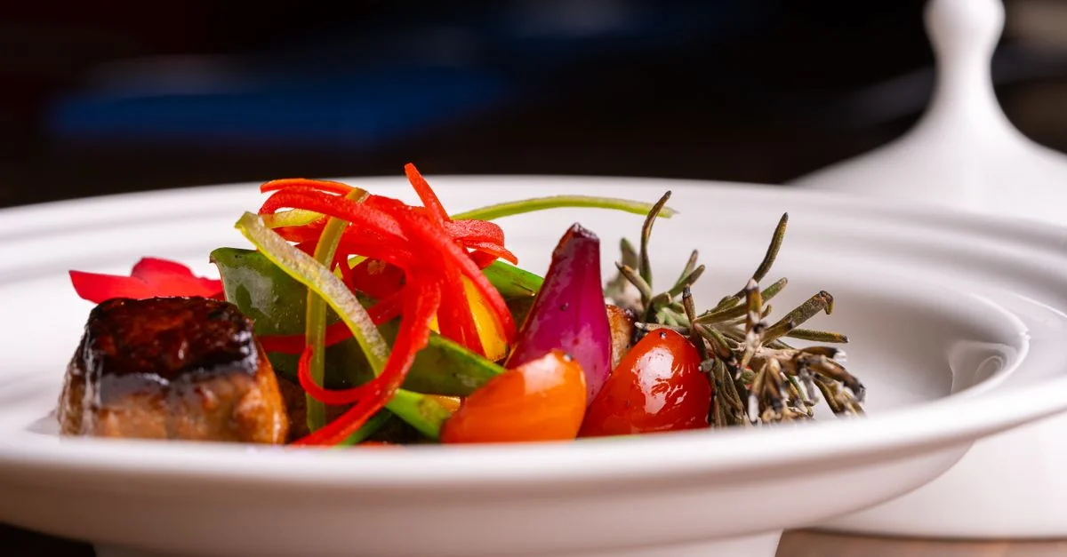 Un plat gourmet vibrant mettant en avant divers légumes élégamment présentés à l'intérieur.