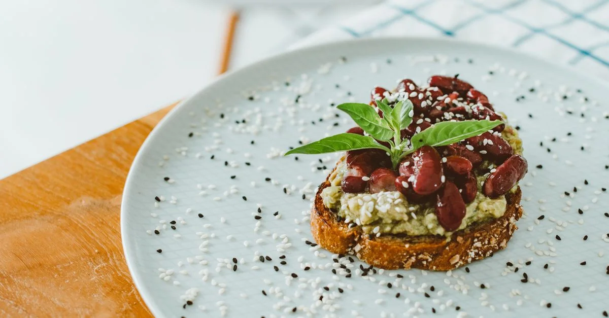 Toasts appétissants garnis d'avocat, de haricots rouges et de graines de sésame sur une assiette.