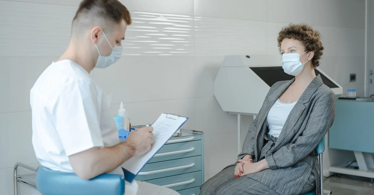 Un médecin en masque consulte un patient dans une clinique, reflétant la nouvelle normalité.
