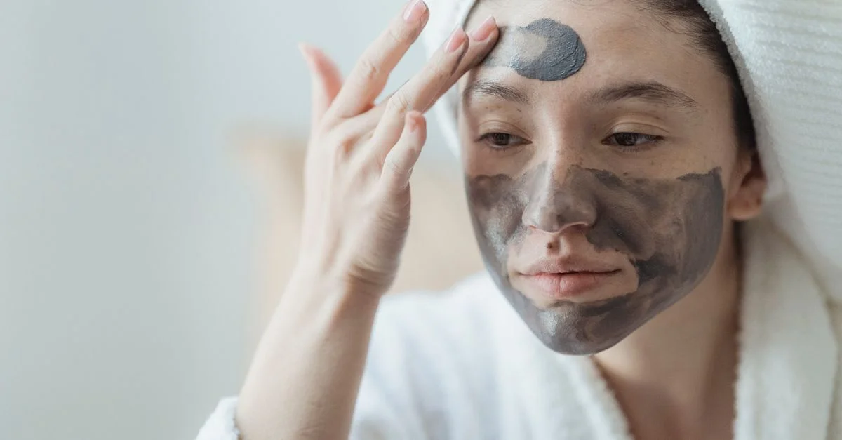 Femme adulte se détendant avec un masque facial en argile, améliorant la santé et le bien-être de la peau à l'intérieur.