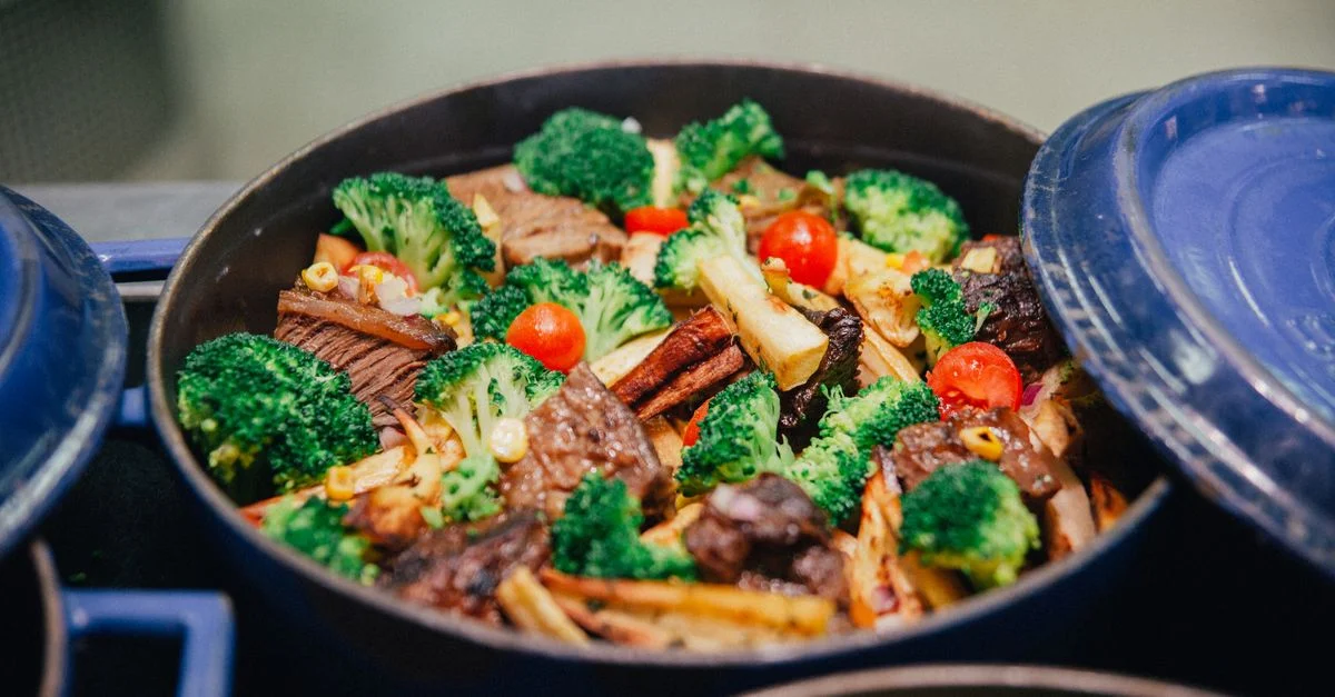 Plat vibrant de brocoli, de bœuf et de légumes dans une poêle bleue, parfait pour le dîner ou le déjeuner.