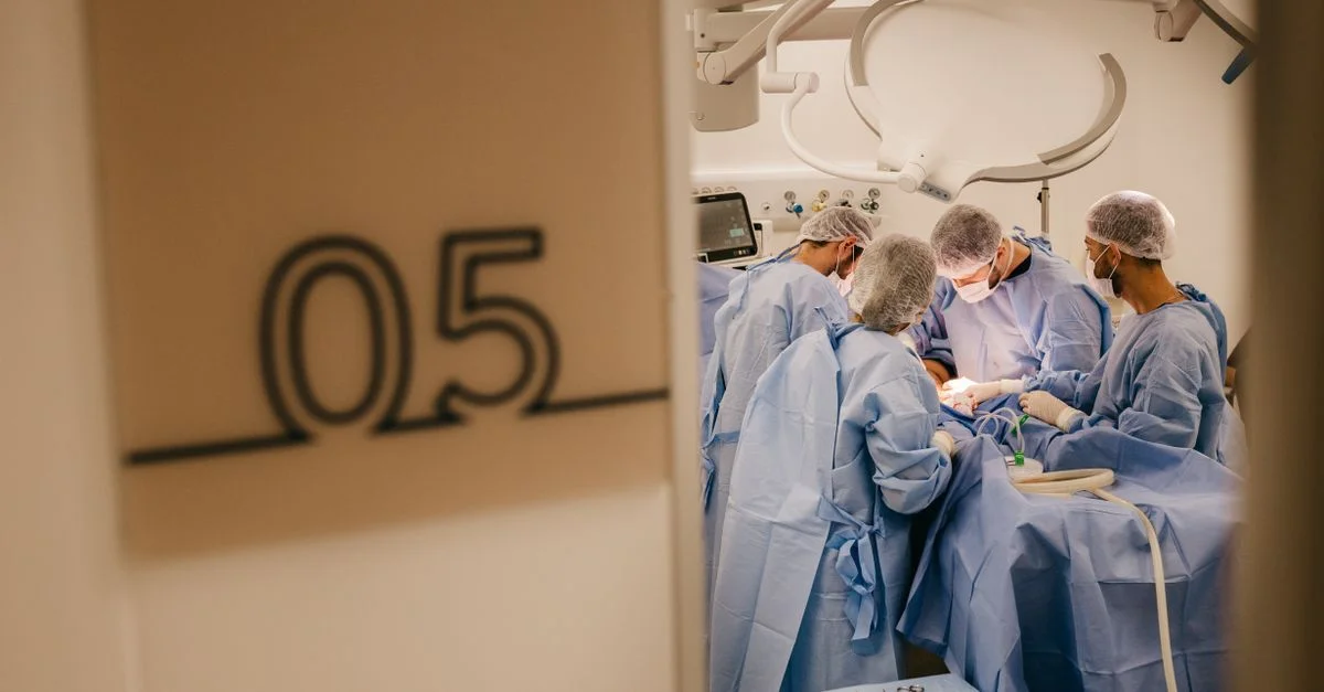 Un groupe de chirurgiens opère dans l'environnement stérile d'un hôpital, se concentrant sur une procédure complexe.