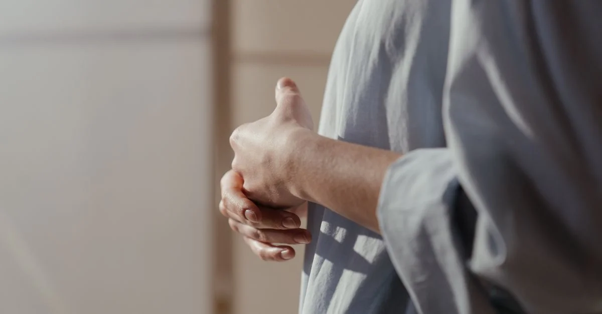 Gros plan sur des mains montrant contemplation et émotion dans une lumière douce.