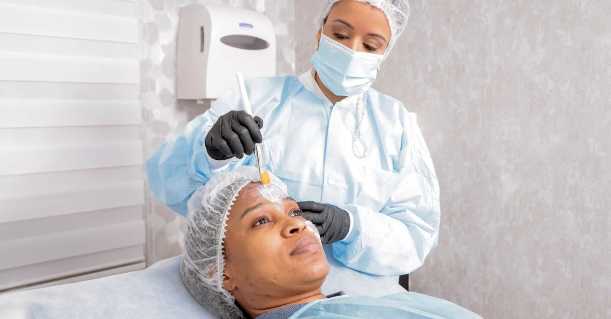 Une esthéticienne applique un soin sur le visage d'une femme dans un spa, en se concentrant sur les soins de la peau.