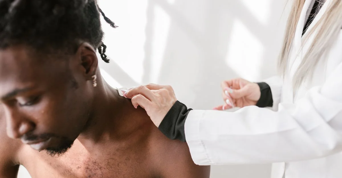 Gros plan sur un homme recevant un massage des épaules pour soulager la douleur à l'intérieur.