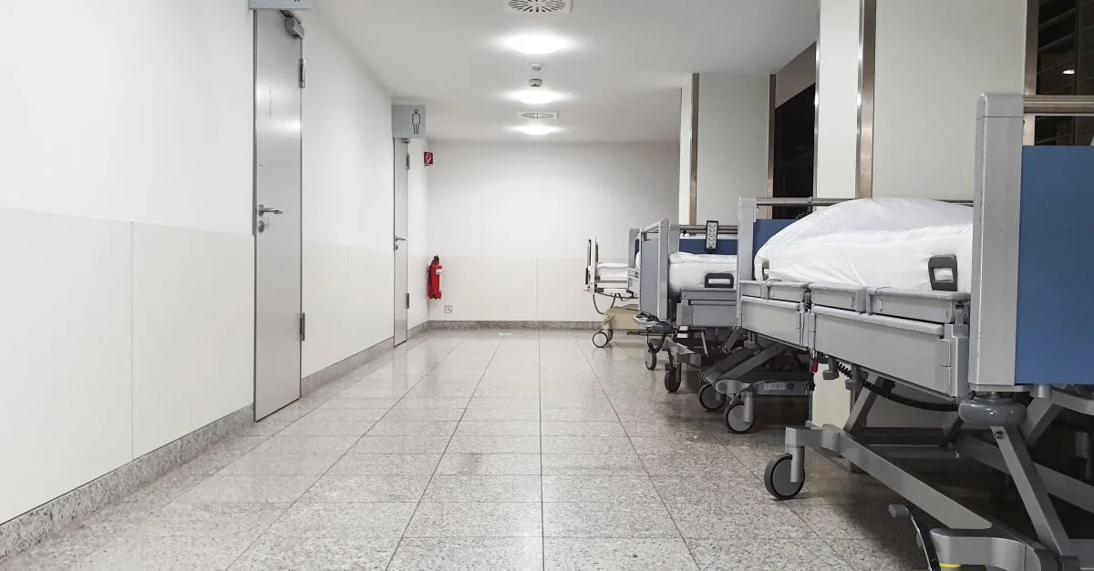 Couloir d'hôpital moderne avec des lits médicaux vides et un environnement stérile.