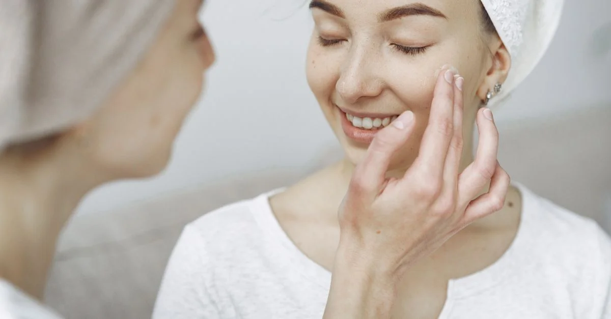Deux femmes profitant d'une routine de soins de la peau, appliquant de la crème et se liant d'amitié à l'intérieur.