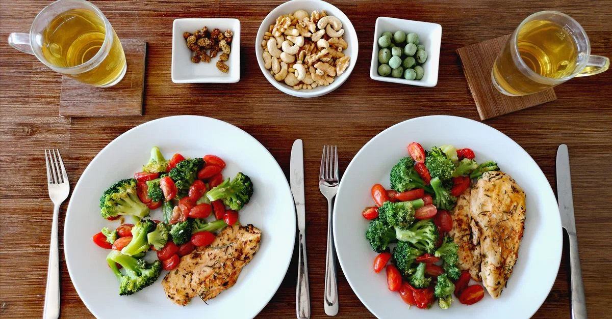 Un délicieux et sain dîner de poulet avec des légumes frais, des noix et du thé dans un cadre convivial.