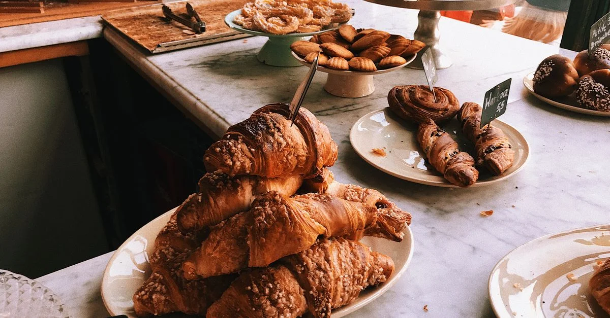 Un assortiment tentant de croissants et de pâtisseries sur un comptoir en marbre, parfait pour un thème de boulangerie.