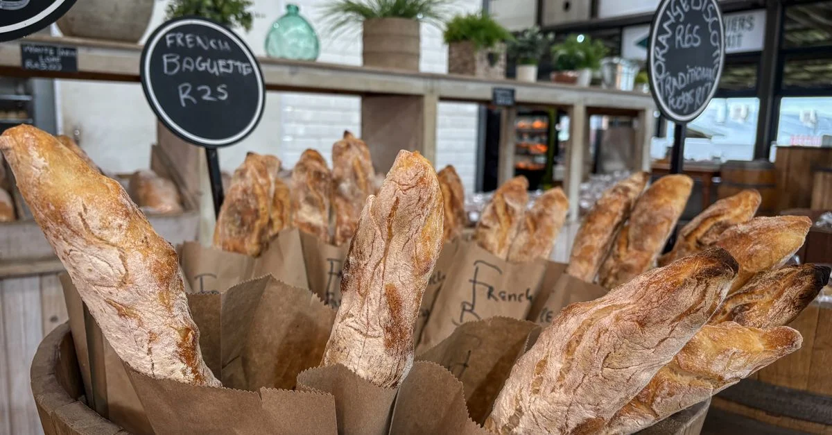 Une exposition de baguettes françaises fraîchement cuites dans un cadre de boulangerie artisanale rustique.