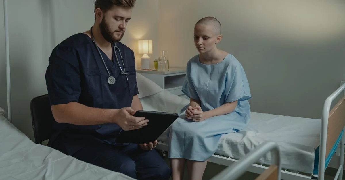 Un médecin dans un service hospitalier consultant un patient avec une tablette numérique.