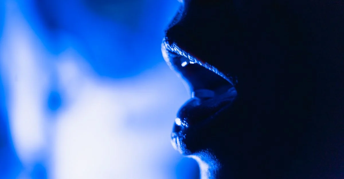 Image abstraite en gros plan d'une silhouette de bouche ouverte dans un éclairage bleu dramatique.