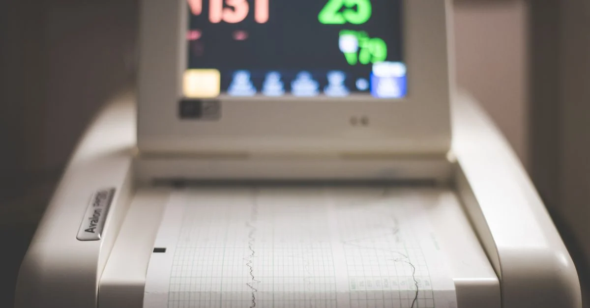 Image détaillée d'une machine de surveillance fœtale électronique montrant les données de fréquence cardiaque et de contractions.